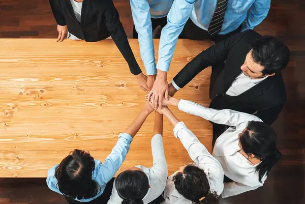 Multiracial business people make synergy hand stack together in meeting room as cooperation or team building for corporate employee in workplace. Panorama top view. Meticulous