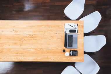 Dizüstü bilgisayarla organize ofis çalışma alanının panoramik üst görüntüsü ve finansal verileri analiz ettim. Modern ve boş şirket konferans odası ya da iş zekası için masa afişi. Uyum