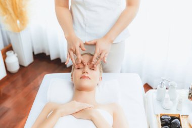 Kafkasyalı kadın stres önleyici kafa masajından ve lüks tatil beldesi ya da otel spa salonundaki modern ışık ortamında yüz güzelliği eğlencelerini şımartmaktan hoşlanıyor. Sessiz.