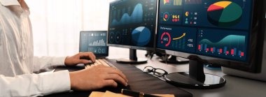 Analizci veri analizi ya da bilgisayar monitöründeki BI gösterge paneli üzerinde çalışıyor. Ticari pazarlama ve strateji planlaması için Fintech 'in şirket ofisindeki finansal verilerini analiz eden bir işadamı. Önde.