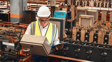 Fabrika mühendisi endüstriyel çelik oluşum makinesini teftiş ediyor. Metal makine mühendisliği denetim denetçisi olarak liderliği gösteriyor..