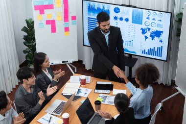 Çeşitli iş arkadaşları bunu şirket işyerinde el sıkışma ve takım çalışmasıyla kutluyor. Başarılı bir toplantıdan sonra el sıkışmayla ya da veri analizi üzerine iş sunumuyla birleşen mutlu iş adamları. Uyum