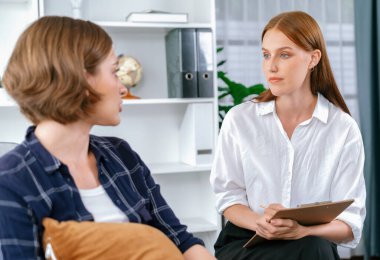 Psikolog, depresyon ya da hayattaki başarısızlıktan sonra keder tedavisi gören üzgün bir kadın. Hayal kırıklığına uğramış genç bir kadın klinikteki duygular hakkında bir psikologla konuşuyor.