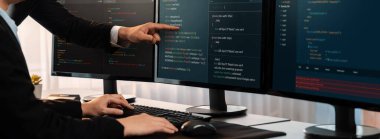 Yazılım geliştirme ekibi ofiste birlikte çalışıyor, bilgisayar ekranında betik görüntülemesi kodluyor. Teknoloji geliştirici şirketinde çalışan programcı ve yazılım mühendisi. Önde.