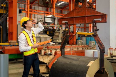 Makine operatörü çelik üretim makinelerini ustalıkla çalıştırıyor, metal fabrikasındaki ağır inşaat mühendisliği malzemeleri için silindir rulo çelik üretiyor. Örnek gösteriliyor