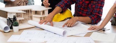 Becerikli mimar takımının tasviri, Mimarlık projesini ev modelleri ve mimari ekipmanlarla toplantı masasında tartışıyor. Yaratıcı tasarım konsepti. - Yakın çekim. Filizlenen.