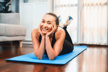 Spor giyim portresindeki son sınıf kadın evde egzersiz paspası üzerinde yoga yapıyor. Huzurlu ve huzurlu bir huzur içinde sağlıklı bir emekli yaşam tarzı. Etki