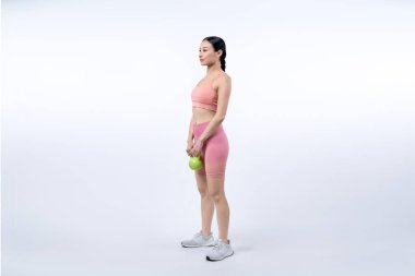 Dinç, enerjik bir kadın izole edilmiş arka planda ağırlık kaldırma egzersizi yapıyor. Genç atletik Asyalı kadın dayanıklılığı ve dayanıklılık eğitimi rutin vücut egzersizi..