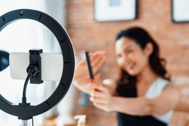 Kadın Etkilenen Vlog video görüntülerini canlı olarak çekiyor. Makyajın çoğu sosyal medya ya da blog 'u anlatıyor. Kozmetik stüdyosu ışıklandırmalı mutlu genç kız çevrimiçi pazarlama oturumu yayını için..