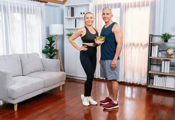 Full body shot, healthy senior couple in sportswear with a bowl of fruit and vegetable. Healthy cuisine nutrition and vegan lifestyle for fitness body physique concept. Clout