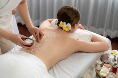 Lüks spa salonlarında sıcak mum ışığında cilt bakımı yaptıran kadın müşteri. Sağlık Spa vücut fırçasında tuz temizleme güzellik tedavisi. Sessiz.