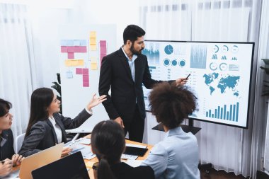 Pazarlama stratejisi için modern toplantıda veri analizi paneli ekranında sunan bir işadamı. Bir grup iş adamıyla konferans odasında iş sunumu. Uyum