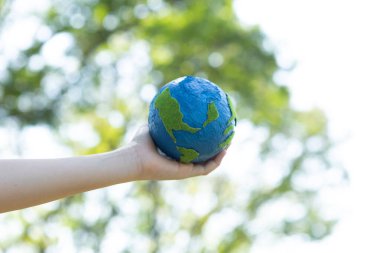 Dünya gezegenini ESG ilkesi ve çevre dostu enerjisiyle daha parlak bir gelecek için Dünya günü olarak el ele tutuşan genç çocuklar. Döngü