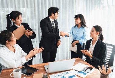 Bir grup iş adamı başarılı bir iş anlaşması toplantısı yaptıktan sonra el sıkıştı. Çeşitli yarış bürosu çalışanları şirket ofisinde pazarlama planlamasında ilerleme kaydettikten sonra kutlama yapıyorlar. Çok titiz.