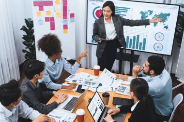 Modern toplantı odasındaki TV ekranında veri analizi paneliyle üst görünüm iş sunumu. İş adamlarının iş pazarlama stratejisini planlamak için beyin fırtınası yapması ya da birlikte çalışması. Uyum