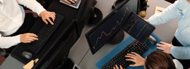 Bir grup tüccar ofis masasında tartışıyor, borsayı işyerinde monitörden izliyorlar. İşadamı ve borsacı borsa şirketinde hisse senedi grafiğini birlikte analiz ediyorlar. Önde.