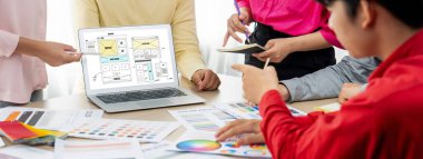 İç mimar ekibinin kırpılmış görüntüsü materyal rengini tartışırken, dizüstü bilgisayar cep telefonu uygulaması ve web sitesi için web sitesi kablo tasarımı görüntülendi. Yaratıcı tasarım ve iş konsepti. Değiştirilmiş.