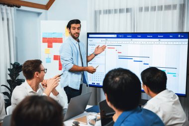 Proje yöneticisi monitörde proje yönetimi yazılım görüntülemesi, proje görevinin ilerlemesini izlemek ve toplantı masasında program planı yapmak suretiyle ekiple iletişim kurar ve işbirliği yapar. Tedbirli