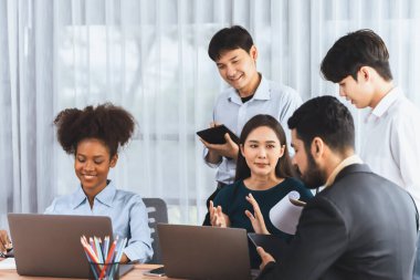 Mutlu iş adamları birlikte çalışır, şirket ofisinde tartışırlar. Profesyonel ve çeşitlilik takım çalışması iş planını bilgisayarda tartışır. Modern çok kültürlü ofis çalışanı. Uyum