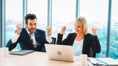 İki mutlu iş adamı ofis toplantı odasında kutlama yapıyor. Başarılı iş adamı, proje başarısını modern işyerindeki meslektaşlarıyla mali raporlar hakkında konuşurken kutluyor. Jivy