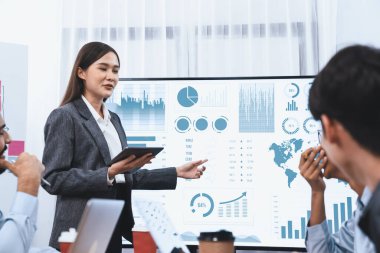 Genç Asyalı iş kadını modern toplantıda TV ekranında veri analizi paneli sunuyor. Bir grup iş adamıyla konferans odasında iş sunumu. Uyum