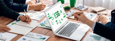 ESG 'nin çevresel sosyal yönetimi, çevre dostu şirket toplantılarında, temiz ve sürdürülebilir gelecekteki ekoloji için çevre korumasını uygulayan iş adamlarıyla dizüstü bilgisayarda sergileniyor. Önde.