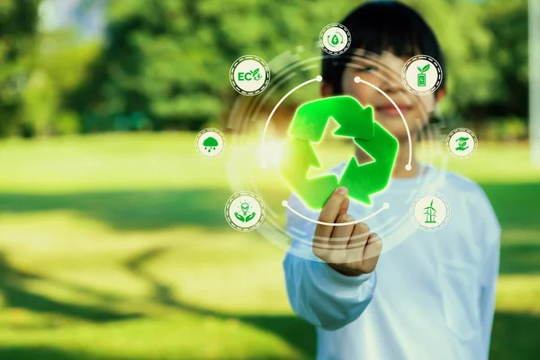 Green recycle symbol for environmental sustainability and natural protection awareness campaign with blurred little boy promoting recyclable ESG practice at outdoor park background. Reliance