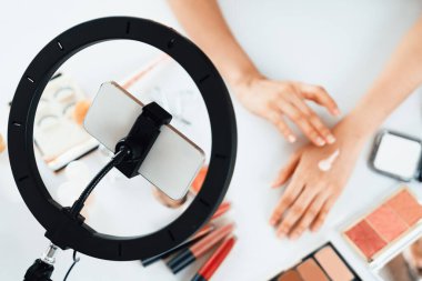 Güzellik blogcusunun ya da nüfuzlu kişinin üst görünümü çevrimiçi canlı yayın platformunda sosyal medya pazarlamasını ya da öğretim elemanlarını görüntüler.