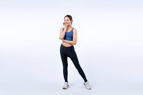 Все тело азиатки в спортивном портрете, улыбаясь и позируя веселый жест. Тренировки с привлекательной девушкой занимаются ее стремлением к здоровому образу жизни. Изолированный фон