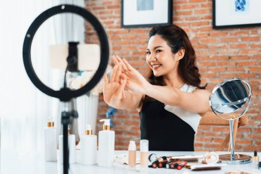 Kadın Etkilenen Vlog video görüntülerini canlı olarak çekiyor. Makyajın çoğu sosyal medya ya da blog 'u anlatıyor. Kozmetik stüdyosu ışıklandırmalı mutlu genç kız çevrimiçi pazarlama oturumu yayını için..