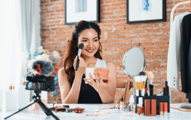 Kadın Etkilenen Vlog video görüntülerini canlı olarak çekiyor. Makyajın çoğu sosyal medya ya da blog 'u anlatıyor. Kozmetik stüdyosu ışıklandırmalı mutlu genç kız çevrimiçi pazarlama oturumu yayını için..