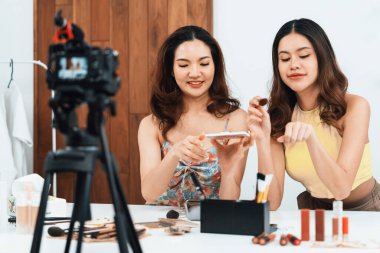 Kadın Etkilenen Vlog video görüntülerini canlı olarak çekiyor. Makyajın çoğu sosyal medya ya da blog 'u anlatıyor. Kozmetik stüdyosu ışıklandırmalı mutlu genç kız çevrimiçi pazarlama oturumu yayını için..