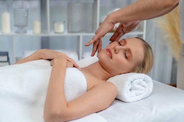 Kafkasyalı kadın stres önleyici kafa masajından ve lüks tatil beldesi ya da otel spa salonundaki modern ışık ortamında yüz güzelliği eğlencelerini şımartmaktan hoşlanıyor. Sessiz.