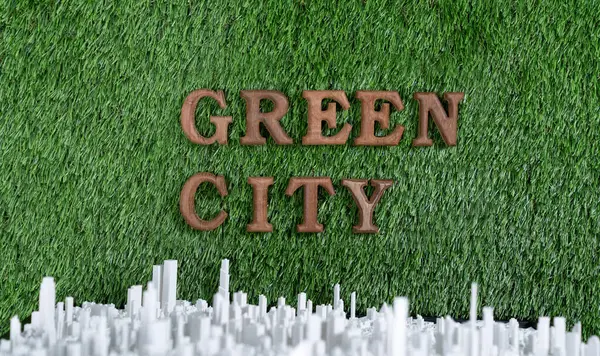 Environment awareness campaign showcase message arranged in Green City on biophilic green grass with cityscape background. Environmental social governance concept idea for sustainable future. Gyre
