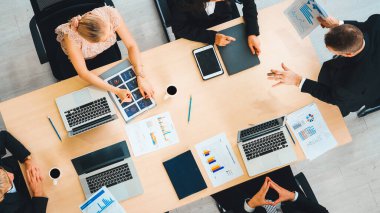 İş adamları grup toplantısı ofiste yukarıdan çekildi. İş kadınları, iş adamları ve ofis çalışanları toplantı masasında proje planlama belgeleriyle takım konferansında çalışıyorlar. Jivy