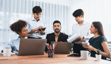 Mutlu iş adamları birlikte çalışır, şirket ofisinde tartışırlar. Profesyonel ve çeşitlilik takım çalışması iş planını bilgisayarda tartışır. Modern çok kültürlü ofis çalışanı. Uyum