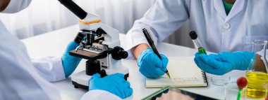 Laboratuvar araştırma ekibi, bilimsel uzmanlık ve laboratuvar ekipmanları ile sağlık hizmetlerini ilerletiyor, yeni ilaçlar araştırıyor ve laboratuvarda tedavi geliştiriyor. Panorama Katı