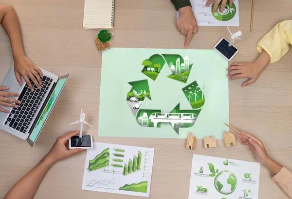 Eco city and recycle illustration placed on a meeting table during a green business meeting discussion. ESG environment social governance and Eco conservative concept. Top view. Delineation.