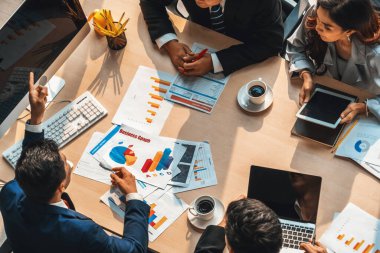 İş adamları grup toplantısı ofiste yukarıdan çekildi. İş kadınları, iş adamları ve ofis çalışanları toplantı masasında proje planlama belgeleriyle takım konferansında çalışıyorlar. Jivy