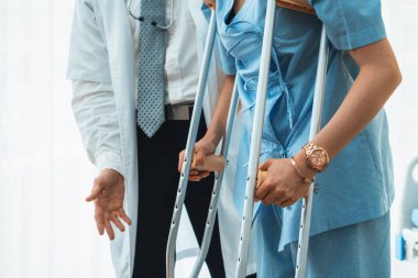 Doktor hastanede koltuk değnekli hastayla ilgileniyor. Fizyoterapist ve bacak yaralanması konsepti. Jivy