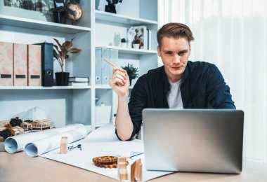Mimar tasarımcının portresi ofiste oturuyor, mimari tasarım projesi için beyin fırtınası fikri, dizüstü bilgisayarla taslaklar hazırlıyor. Mimaride profesyonel ve modern teknoloji. Tekrarlama
