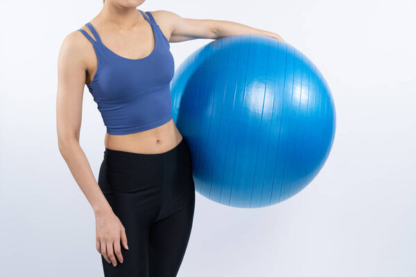 Молодая привлекательная азиатская женщина портрет в спортивной одежде с фитнес мяч таргетинг на мышцы живота для эффективной энергичной повседневной тренировки. Студийные съемки и изолированный фон. Бдительность