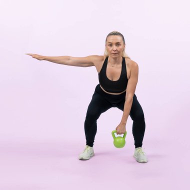 Vücut uzunluğu tam, atletik ve sportif yaşlı kadın izole edilmiş arka planda vücut çalışması için kettlebell ile hiç bir şey yapmıyor. Emeklilikten sonra sağlıklı, aktif bir fiziğe ve vücut bakımına sahip. Etki