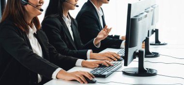 Ofiste çalışan kulaklık takan işadamları uzak müşteri ya da meslektaşlarını desteklemek için çalışıyorlar. Çağrı merkezi, tele pazarlama, müşteri destek acentesi telefon konferansında konuşma hizmeti sunar.