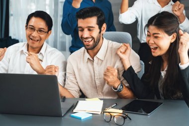 Heyecanlı ve mutlu bir ofis çalışanı başarılı bir stratejik iş pazarlama planlaması yaptıktan sonra kutlama yapıyor. Takım çalışması ve olumlu tutum verimli ve destekleyici bir iş yeri yaratır. Tedbirli