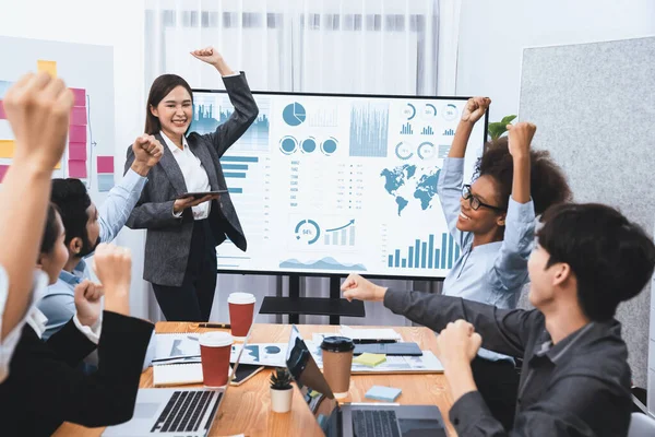 stock image Business people celebrate after successful presentation or meeting on data analysis display on TV screen. Happy team gathers in office room, cheer to collaboration with celebratory gesture. Concord