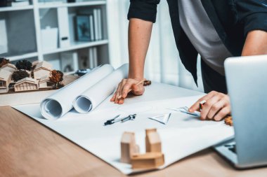 Mimar tasarımcının, ofis masasındaki plan kağıdına ev planı taslağı hazırlıyorum. Mimar, kalem ve araçla dikkatlice ev iç mimarisi düzenini çizer. Tekrarlama