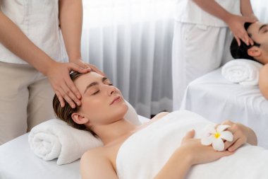 Kafkasyalı çift stres önleyici kafa masajının keyfini çıkarıyor ve lüks otellerde ya da otel spa salonlarında gündüz kaplıcalarında yüz güzelliği eğlencelerini şımartıyor. Sessiz.