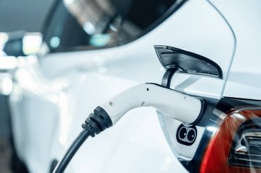 Alış veriş merkezinin otoparkında EV elektrikli araba şarjı şehir merkezindeki sürdürülebilirlik yaşam tarzını yeşil, temiz, yeniden şarj edilebilir elektrikli araç iç organları ile gösteriyor.