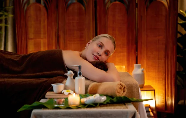 白种人女性顾客喜欢在豪华度假胜地或宾馆里 在温暖的烛光下享受轻松的抗压力温泉按摩和美肤娱乐休闲 — 图库照片